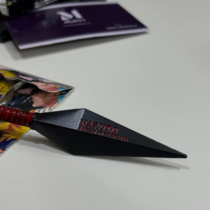 Black kunai with red handle on a white surface, featuring 'Naruto' branding.